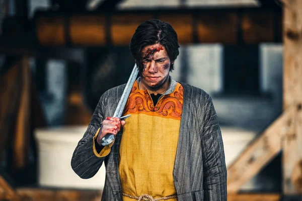 Retrato de um jovem guerreiro medieval em armadura com espada em seu — Fotografia de Stock