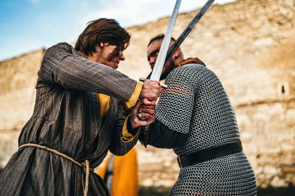 Dois antigos guerreiros de armadura com armas lutando com espadas — Fotografia de Stock