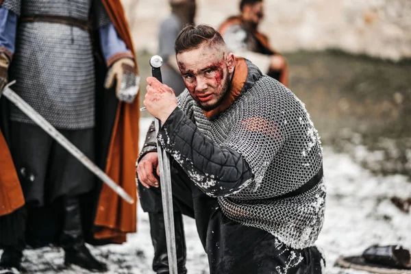 Um guerreiro medieval em cadeia armadura de correio e manto ajoelha-se em fron — Fotografia de Stock