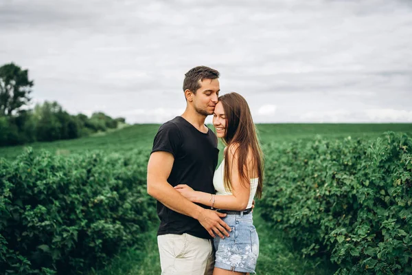 Joven pareja amorosa abrazándose suavemente en el fondo de la cu verde — Foto de Stock