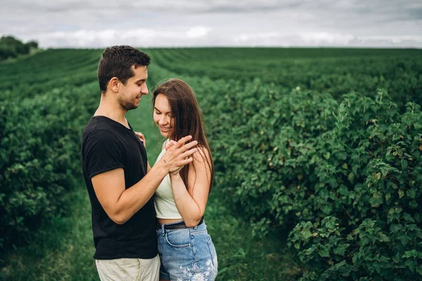 Joven pareja amorosa abrazándose suavemente en el fondo de la cu verde —  Fotos de Stock