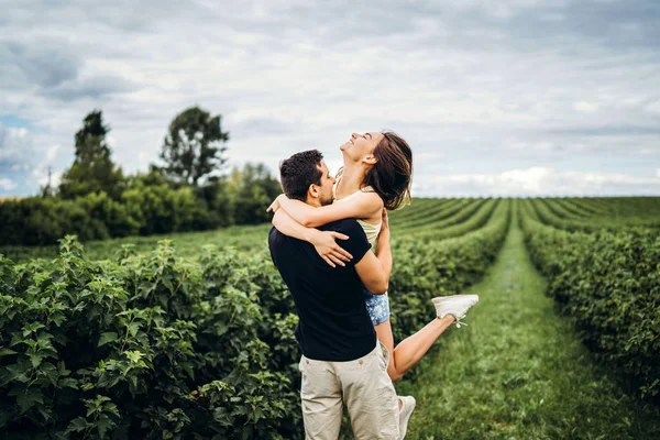 Ніжна закохана пара ходить у поле смородини. Чоловічі свити — стокове фото