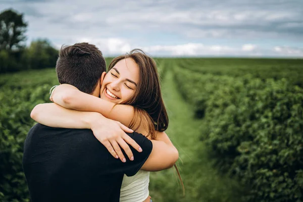 Cute young girl with long hair hugs her lover, smiling and with — Stock Photo, Image