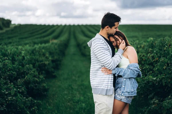 Joven pareja amorosa abrazándose suavemente en el fondo de la cu verde —  Fotos de Stock