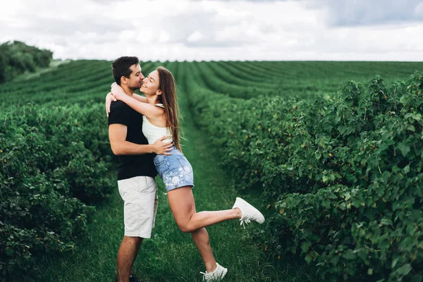 Młoda kochająca się para delikatnie przytula się na tle zielonego cu — Zdjęcie stockowe