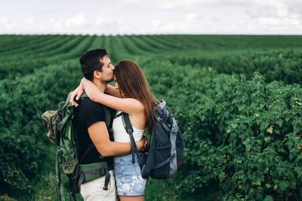 Portret van gelukkig jong stel met rugzakken op het veld in sp — Stockfoto