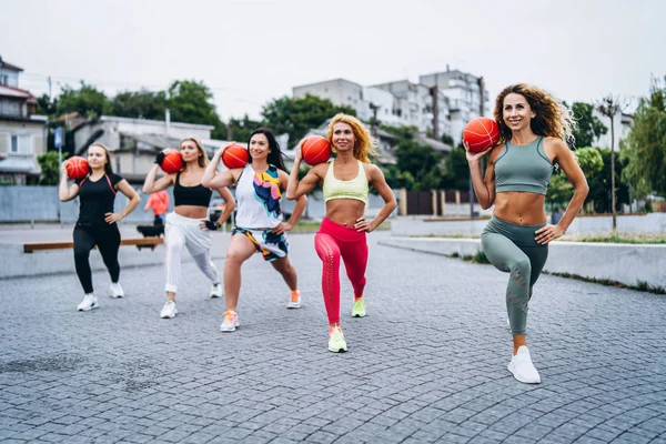 Un gruppo di donne sportive sono in posa presso la fotocamera, eseguendo esercizi — Foto Stock