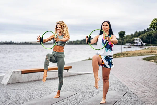 Dos mujeres practican ejercicios de yoga en una esterilla con un deporte especial — Foto de Stock