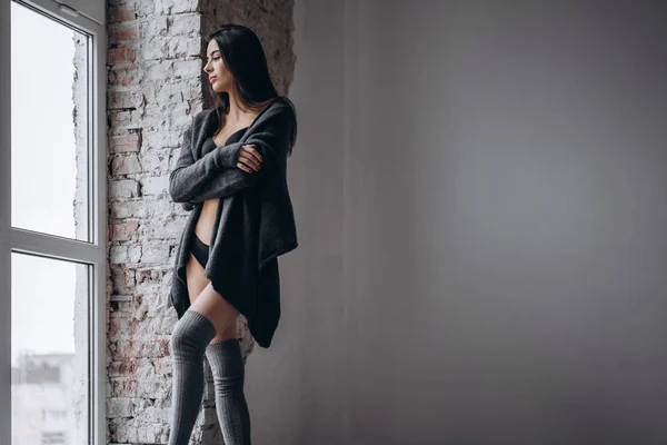 Young brunette in black underwear, knitted knee pads and cardiga — 스톡 사진