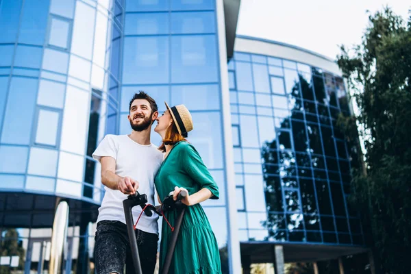 Een jong romantisch paar met elektrische scooters op een date, walkin — Stockfoto