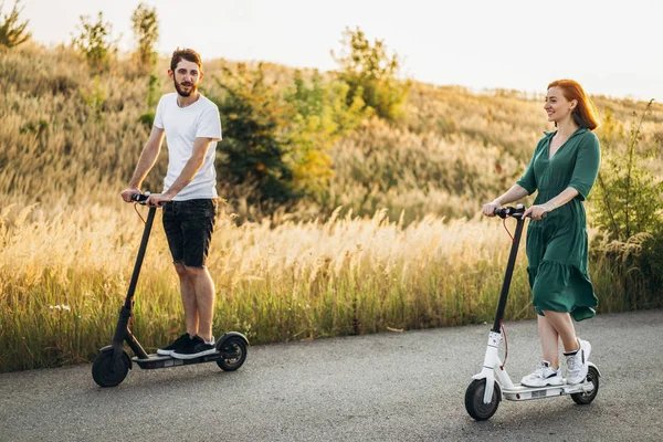 Giovane coppia in vacanza divertendosi a guidare scooter elettrico su — Foto Stock