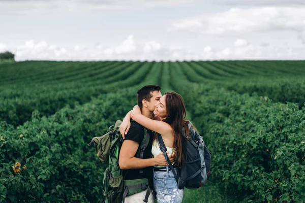 Retrato de feliz pareja joven con mochilas en el campo en sp —  Fotos de Stock