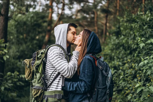Young couple with backpacks on their backs in the forest. Loving — 스톡 사진