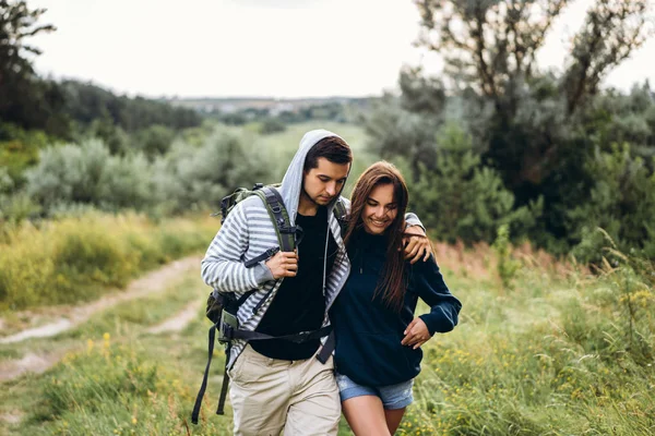 Giovane coppia con zaini sulla schiena nella foresta. Amare — Foto Stock