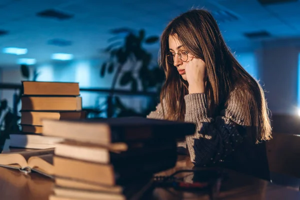 Müde Studentin am Abend sitzt auf seinem Arm angelehnt in — Stockfoto