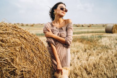 Güneş gözlüğü ve hasır şapkalı, uzun saçlı güzel bir kız.