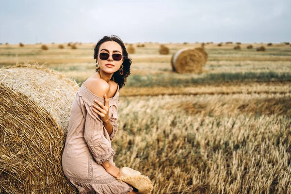 Glimlachende vrouw in een zonnebril met blote schouders op een achtergrond — Stockfoto