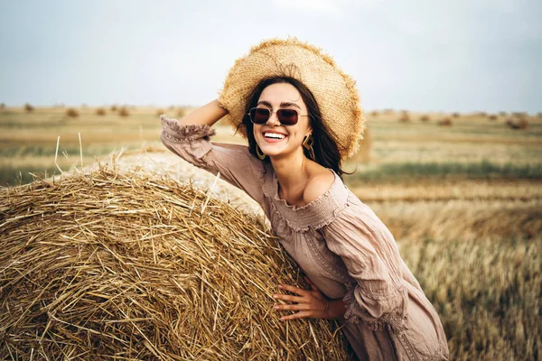 Glimlachende vrouw in een zonnebril met blote schouders op een achtergrond — Stockfoto
