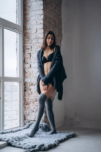 Young brunette in black underwear, knitted knee pads and cardiga — 스톡 사진