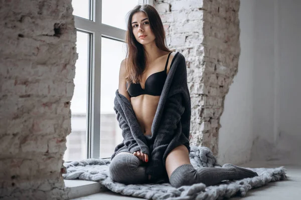 Young brunette in black underwear, knitted knee pads and cardiga — 스톡 사진