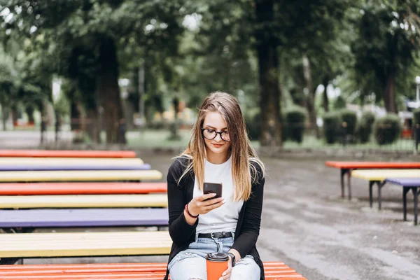 Chica Joven Gafas Mira Teléfono Celular Segunda Mano Sostiene Una — Foto de Stock