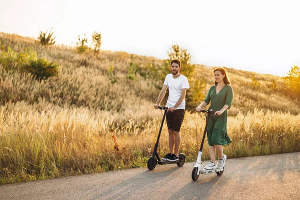 Coppia Giovane Vacanza Divertendosi Alla Guida Scooter Elettrici Sulla Strada — Foto Stock