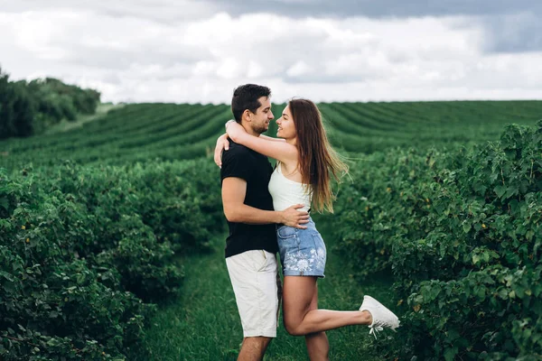 Joven Pareja Amorosa Abrazándose Suavemente Fondo Las Plantaciones Grosellas Verdes — Foto de Stock