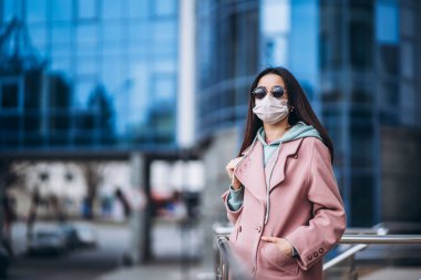 Tıp maskeli bir kadın, boş bir şehirde, dışarıda. Sağlık koruma ve virüs salgınının önlenmesi, koronavirüs, COVID-19, salgın, salgın, bulaşıcı hastalıklar, karantina kavramı