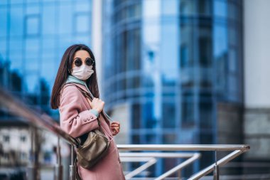 Tıp maskeli bir kadın, boş bir şehirde, dışarıda. Sağlık koruma ve virüs salgınının önlenmesi, koronavirüs, COVID-19, salgın, salgın, bulaşıcı hastalıklar, karantina kavramı