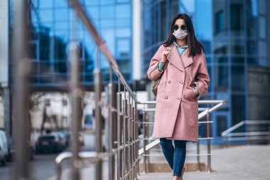 Tıp maskeli bir kadın, boş bir şehirde, dışarıda. Sağlık koruma ve virüs salgınının önlenmesi, koronavirüs, COVID-19, salgın, salgın, bulaşıcı hastalıklar, karantina kavramı