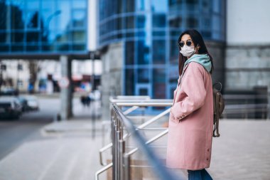 Tıp maskeli bir kadın, boş bir şehirde, dışarıda. Sağlık koruma ve virüs salgınının önlenmesi, koronavirüs, COVID-19, salgın, salgın, bulaşıcı hastalıklar, karantina kavramı