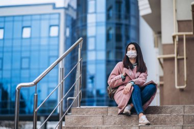 Tıp maskeli bir kadın, boş bir şehirde, dışarıda. Sağlık koruma ve virüs salgınının önlenmesi, koronavirüs, COVID-19, salgın, salgın, bulaşıcı hastalıklar, karantina kavramı
