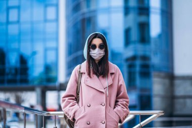 Tıp maskeli bir kadın, boş bir şehirde, dışarıda. Sağlık koruma ve virüs salgınının önlenmesi, koronavirüs, COVID-19, salgın, salgın, bulaşıcı hastalıklar, karantina kavramı