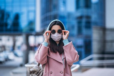 Tıp maskeli bir kadın, boş bir şehirde, dışarıda. Sağlık koruma ve virüs salgınının önlenmesi, koronavirüs, COVID-19, salgın, salgın, bulaşıcı hastalıklar, karantina kavramı