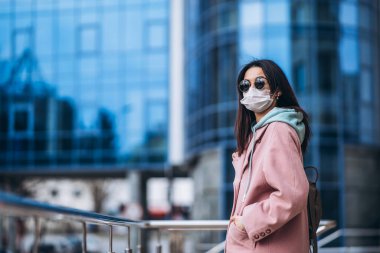 Tıp maskeli bir kadın, boş bir şehirde, dışarıda. Sağlık koruma ve virüs salgınının önlenmesi, koronavirüs, COVID-19, salgın, salgın, bulaşıcı hastalıklar, karantina kavramı