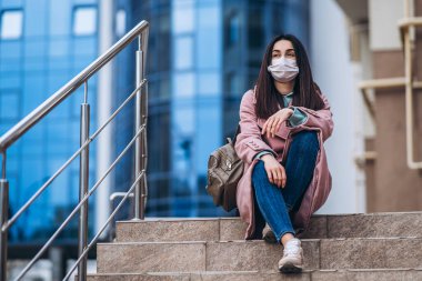 Tıp maskeli bir kadın, boş bir şehirde, dışarıda. Sağlık koruma ve virüs salgınının önlenmesi, koronavirüs, COVID-19, salgın, salgın, bulaşıcı hastalıklar, karantina kavramı