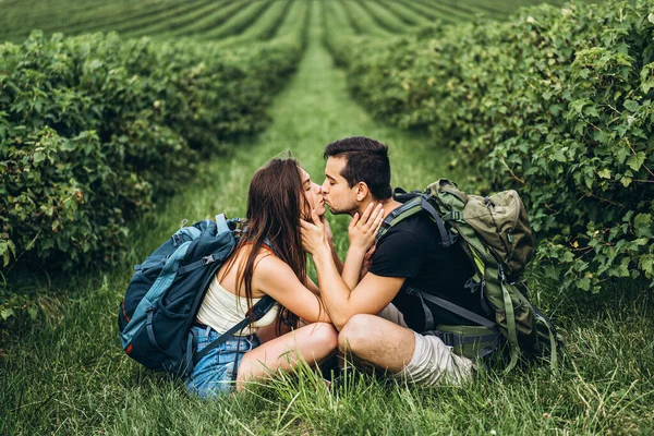 Hombre Mujer Con Mochilas Espalda Sentados Abrazados Hierba Verde Entre —  Fotos de Stock