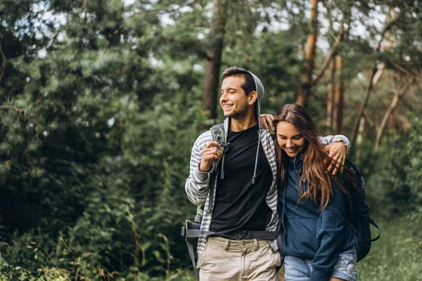 Giovane Coppia Con Zaini Sulla Schiena Sorridente Passeggiando Nella Foresta — Foto Stock