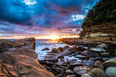 Long exposure of the sunrise on Avoca beach in New South Wales, Australia. There is a few fishermen at a distance and the sky is fantastic clipart