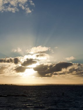 Güneş okyanusun üzerindeki bulutlara nüfuz etmeye çalışıyor.