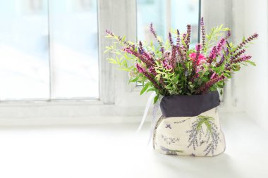 Pencere kenarında bir buket çiçek olduğunu