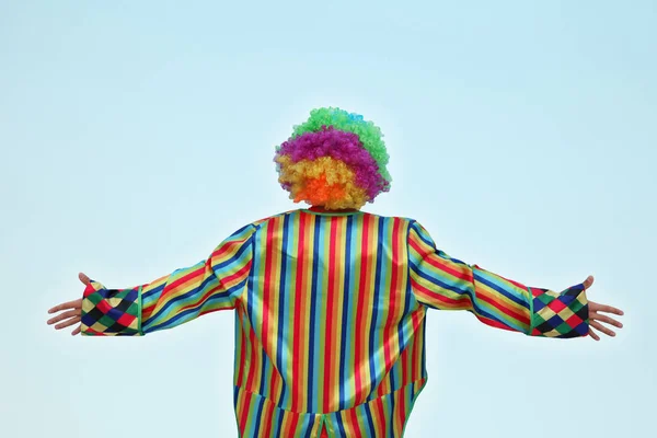 Clown in piedi con le spalle a noi, isolato contro un azzurro — Foto Stock