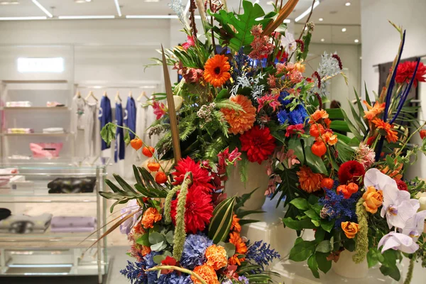 Arreglo floral exótico en una tienda de ropa femenina . — Foto de Stock