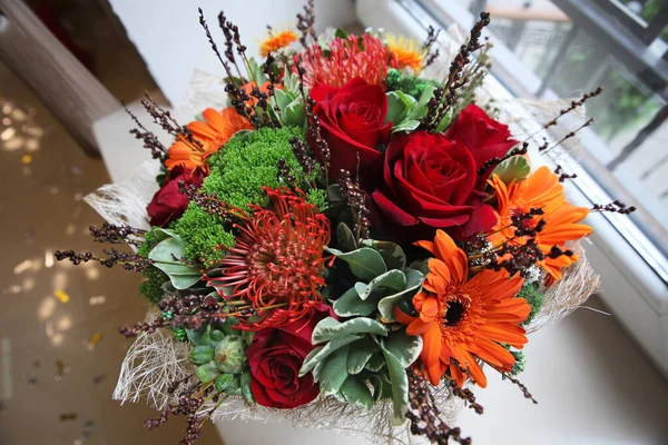 Vista superior de um buquê de rosas vermelhas e gerberas laranja com gree — Fotografia de Stock