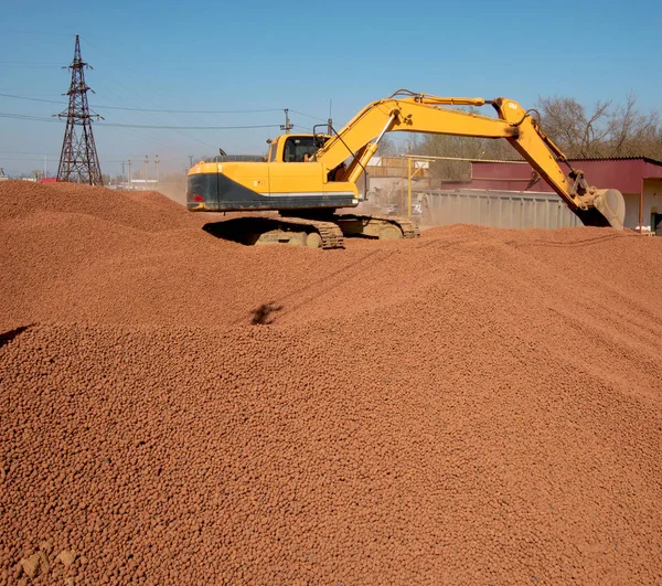 Stora gula grävmaskin levererar Lättklinker — Stockfoto