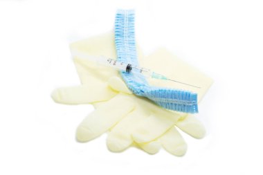 Cerrahi eldiven, maske, kap ve beyaz arka plan üzerinde şırınga.