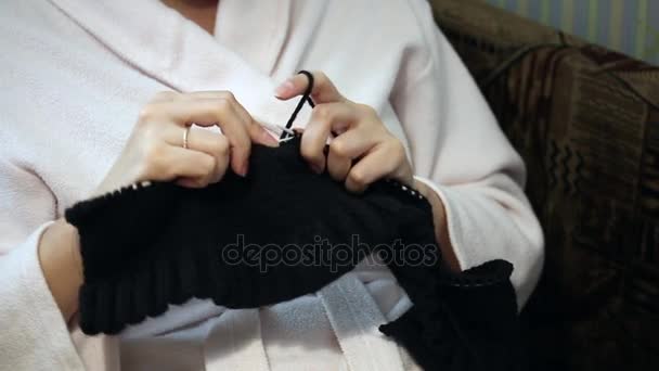 Een vrouw in een housecoat die zich bezighouden met breien. — Stockvideo