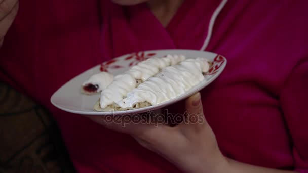 Girl eats pancakes. Pancakes filled with jam, topped with sour cream on top. — Stock Video