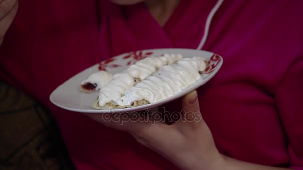 Tjej äter pannkakor. Pannkakor fyllda med sylt, toppad med creme fraiche på toppen. — Stockvideo