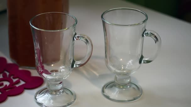 Karottensaft wird aus einem Krug in zwei Gläser gegossen. Danach die Brille in die Hand nehmen. — Stockvideo